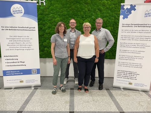 Ein Gruppenfoto der Teilnehmer unseres Landesverbandes auf der Einweihungsfeier der LAG Selbsthilfe. Zu sehen sind Susanne Brockhaus, Thomas Schneider, Cornelia Punke und Stefan Bauerfeind. Links und rechts von Ihnen stehen zwei Banner der LAG Selbsthilfe